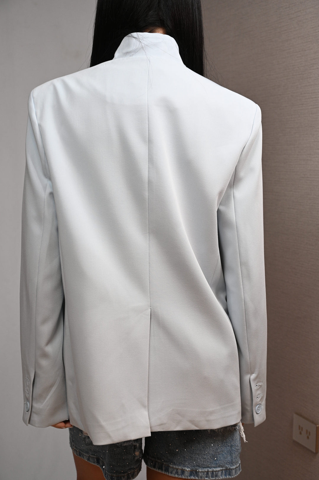 Vista trasera del blazer oversized con caída boxy y hombro caído